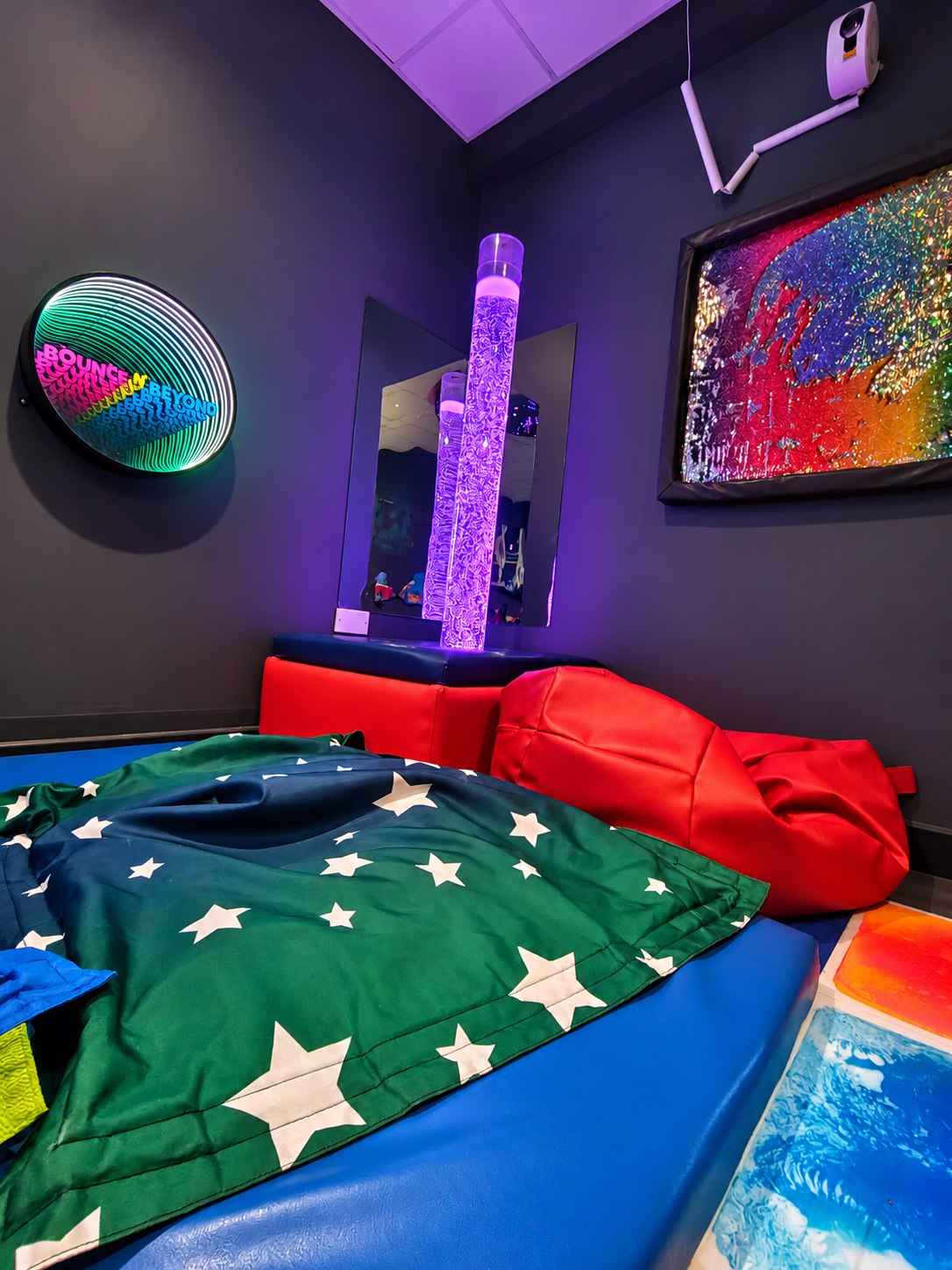 Purple bubble tube, tactile panel and soft furnishings in the sensory room