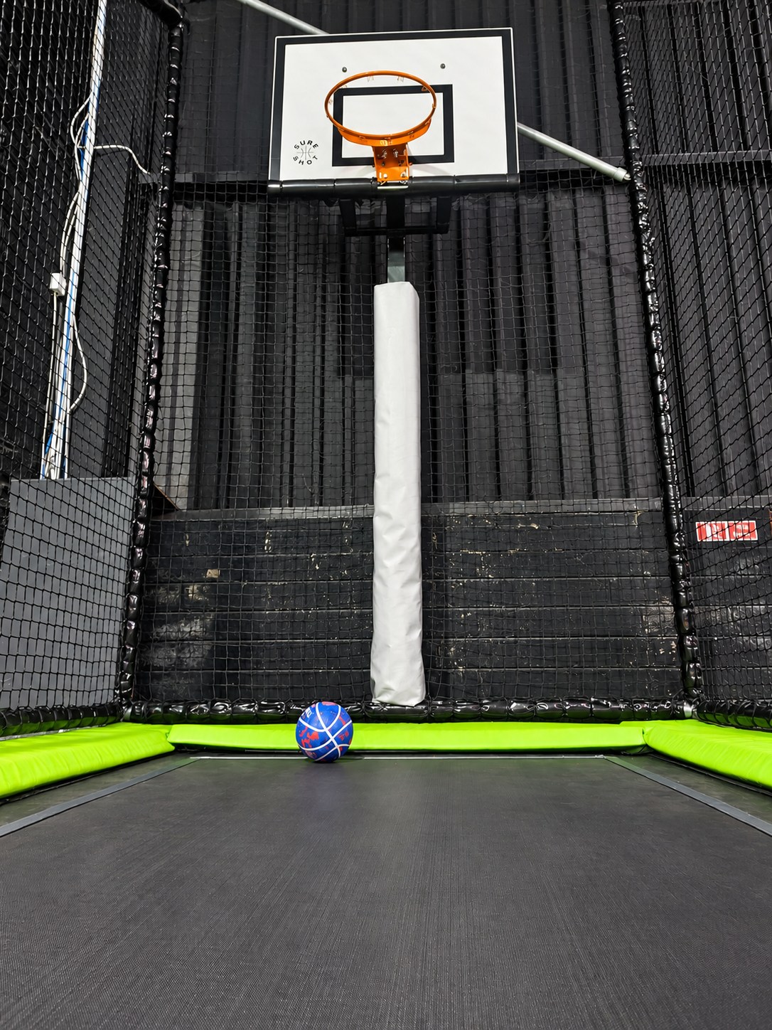 Basketball hoop above a trampoline lane